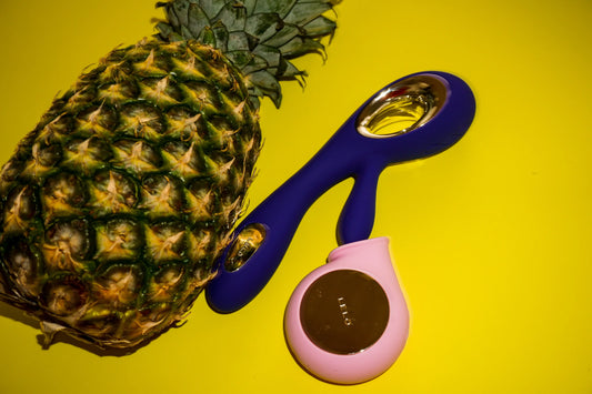 Ananas sur fond jaune avec deux sextoys posés à côté.